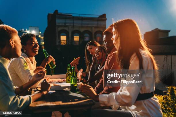 friends are dining together with pizza - rooftop dining stock pictures, royalty-free photos & images