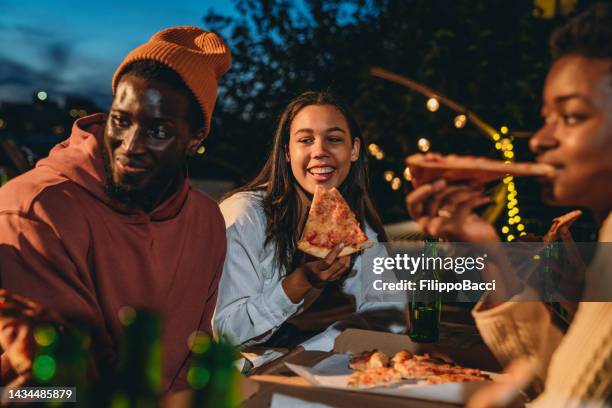 los amigos están cenando juntos con pizza - pizza fotografías e imágenes de stock