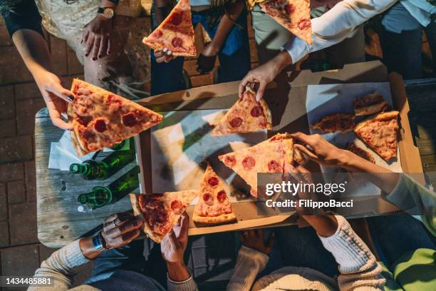 dinner party with friends - high angle view of people taking pizza slices - pizza share bildbanksfoton och bilder