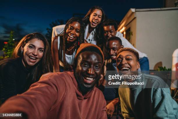 multiethnische gruppe von menschen macht während einer dinnerparty zusammen ein selfie - black people partying stock-fotos und bilder