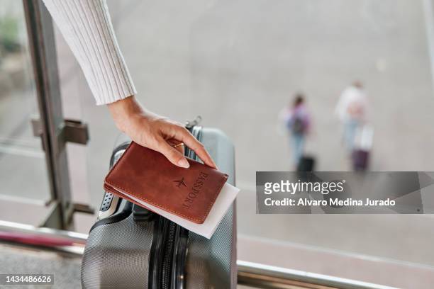 woman hand with suitcase and passport waiting at airport terminal. - pasaporte fotografías e imágenes de stock