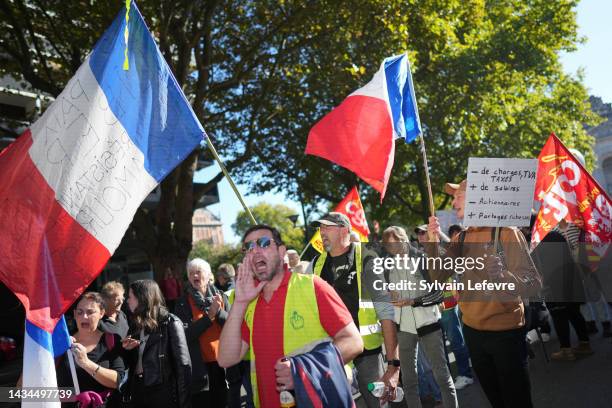 Protesters hold flags as they march during a demonstration on October 18, 2022 in Lille, France, after the CGT and FO trade unions called for a...