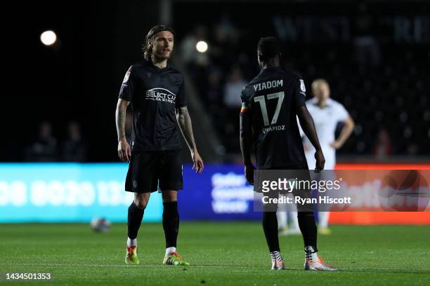 Jeff Hendrick of Reading talks with teammate Andy Yiadom as players of Swansea City and Reading wait for play to resume after power issues effect the...