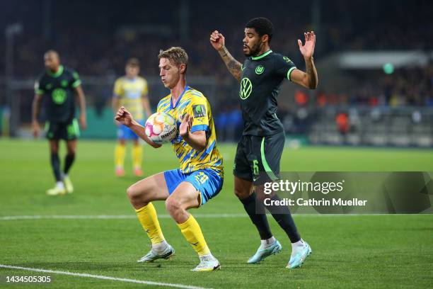 Lion Lauberbach of Eintracht Braunschweig controls the ball while under pressure from Paulo Otavio of VfL Wolfsburg during the DFB Cup second round...