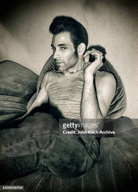 Portrait of American rockabilly singer Robert Gordon smoking on a couch in New York City, 1982.