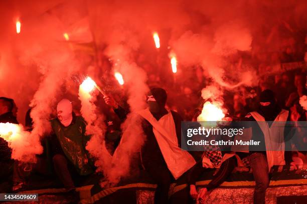 Fans burn flares during the DFB Cup second round match between Eintracht Braunschweig and VfL Wolfsburg at Eintracht Stadion on October 18, 2022 in...