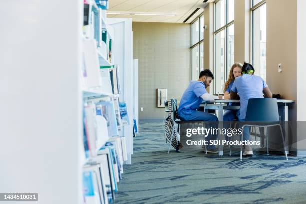 diverse group of medical students meet in library to study - medical school stock pictures, royalty-free photos & images
