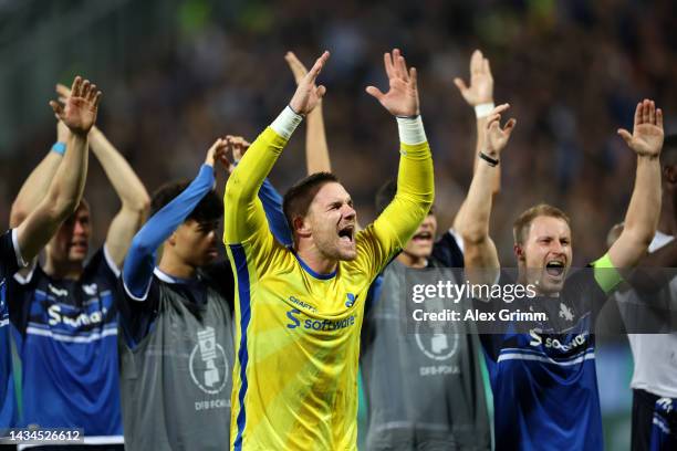 Marcel Schuhen of SV Darmstadt 98 celebrates with teammates towards the fans following their side's victory in the DFB Cup second round match between...