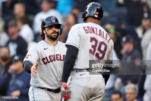 Austin Hedges of the Cleveland Guardians is congratulated by Oscar Gonzalez after scoring a run against the New York Yankees during the third inning...