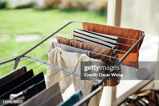 Drying laundry on drying rack by the window with sunlight