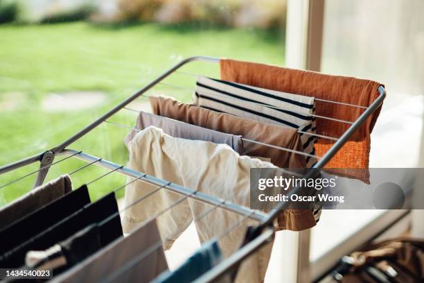 drying laundry on drying rack by the window with sunlight - seco imagens e fotografias de stock