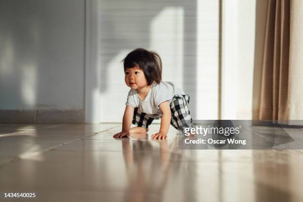asian toddler learning to walk at home - weibliches baby stock-fotos und bilder
