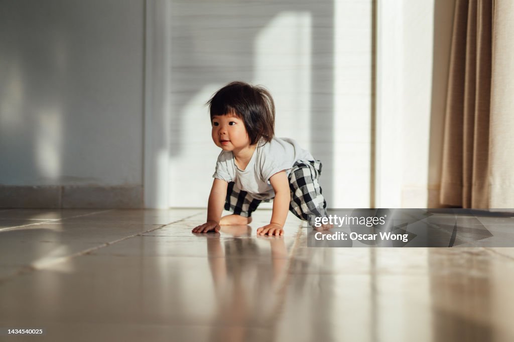 Asian toddler learning to walk at home