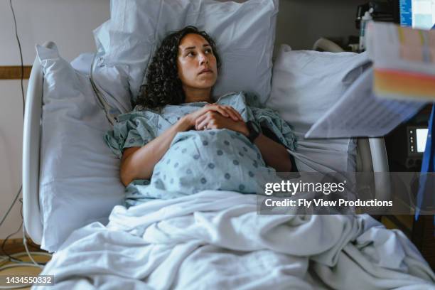 pregnant woman in labor at the hospital speaking with a doctor - delivery character stock pictures, royalty-free photos & images