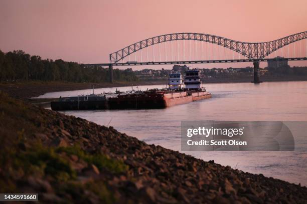 Tug holds barges along the rocky shoreline of the Mississippi River on October 18, 2022 in Memphis, Tennessee. Lack of rain in the Ohio River Valley...