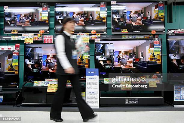 Salesclerk walks past Sharp Corp. Aquos liquid crystal display televisions at the Labi Ofuna electronics store, operated by Yamada Denki Co., in...