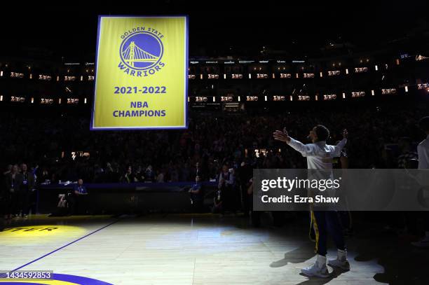 Stephen Curry of the Golden State Warriors watches the championship banner being raised during the ring ceremony prior to the game against the Los...