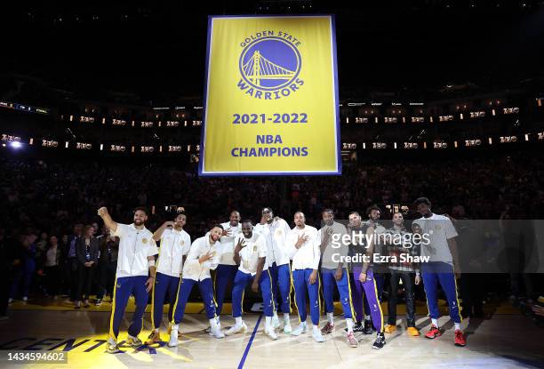 Golden State Warriors players pose with their Championship rings below the Championship banner during a ceremony prior to the game against the Los...