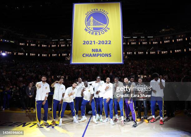 Golden State Warriors players pose with their Championship rings below the Championship banner during a ceremony prior to the game against the Los...