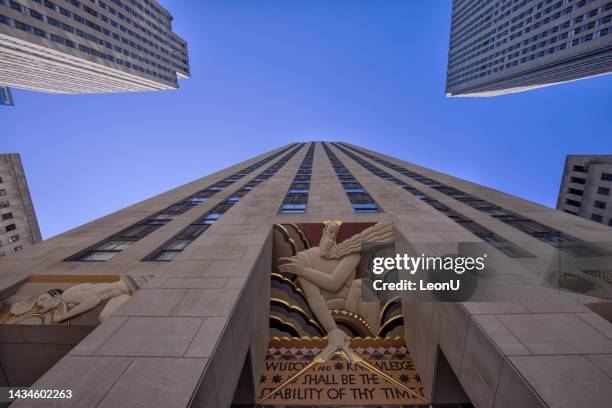 wisdom and knowledge shall be the stability of thy times and sculptures at the entrance of the rockefeller center in new york city - rockefeller centre stock pictures, royalty-free photos & images