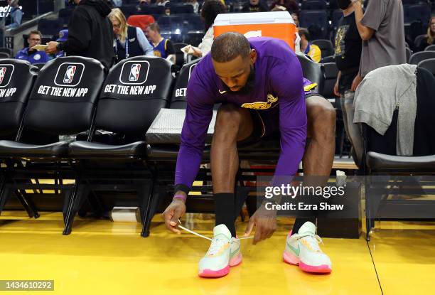 LeBron James of the Los Angeles Lakers laces up his shoes prior to the game against the Golden State Warriors at Chase Center on October 18, 2022 in...