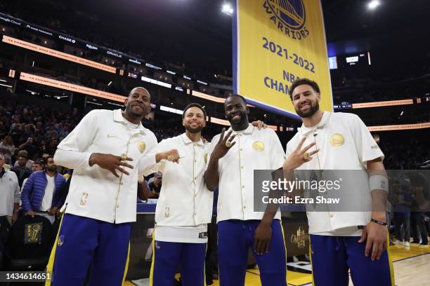 Andre Iguodala, Stephen Curry, Draymond Green, and Klay Thompson of the Golden State Warriors pose with their championship rings in front of a...
