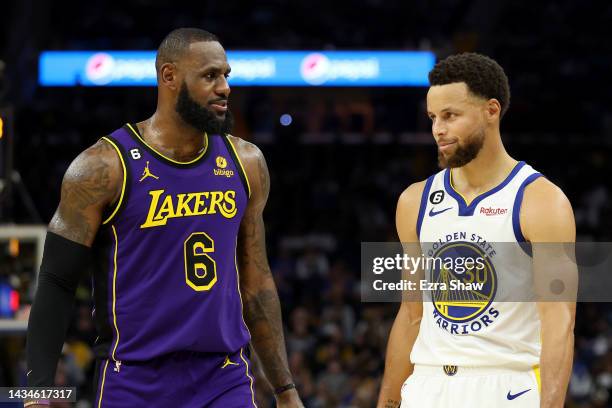 LeBron James of the Los Angeles Lakers speaks to Stephen Curry of the Golden State Warriors during their game at Chase Center on October 18, 2022 in...