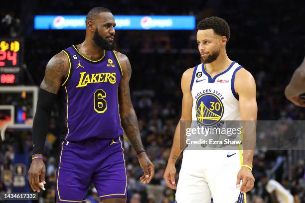 LeBron James of the Los Angeles Lakers speaks to Stephen Curry of the Golden State Warriors during their game at Chase Center on October 18, 2022 in...