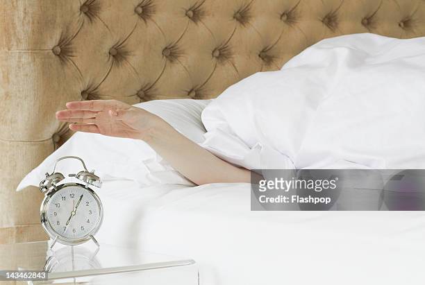 woman in bed reaching out to alarm clock - time blocking stock pictures, royalty-free photos & images