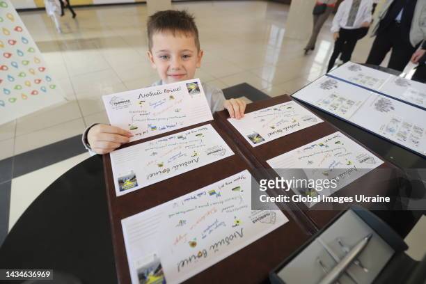 Boy featured on a postage stamp “We thank the defenders” takes part at the stamp cancellation ceremony on October 14, 2022 in Lviv, Ukraine. The...
