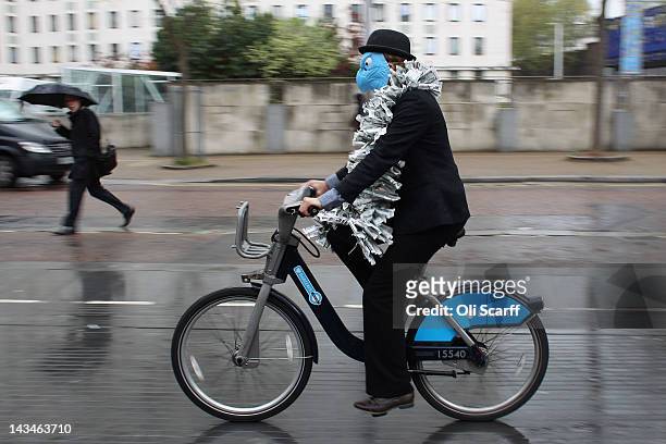 Protester dressed as a suited eagle rides a Barclays cycle hire bike past the Royal Festival Hall which is hosting the Barclays bank AGM on April 27,...