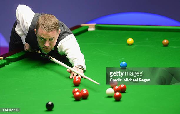 Stephen Hendry of Scotland plays a shot in his round two match against John Higgins of Scotland during the Betfred.com World Snooker Championship at...