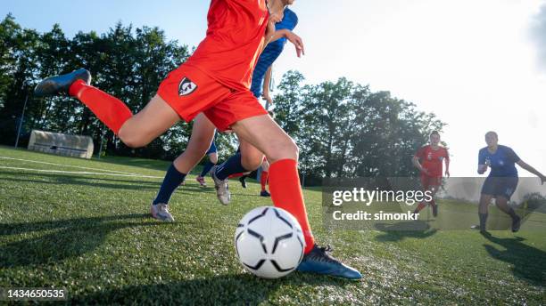 female player kicking ball - girl kicking stock pictures, royalty-free photos & images