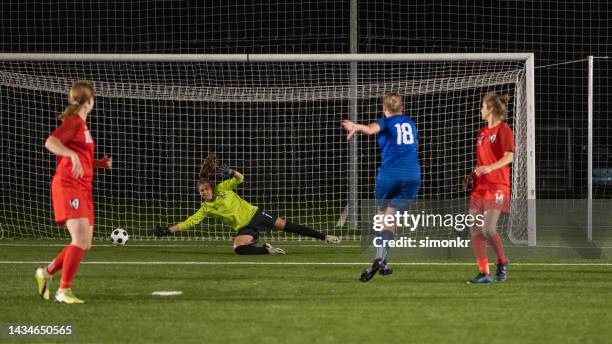 goalkeeper jumping to catch football - woman goalie stock pictures, royalty-free photos & images