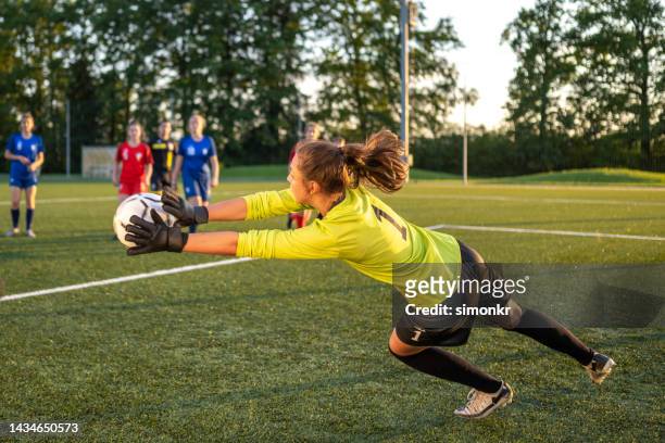torwart springt, um fußball zu fangen - goalkeeper soccer stock-fotos und bilder