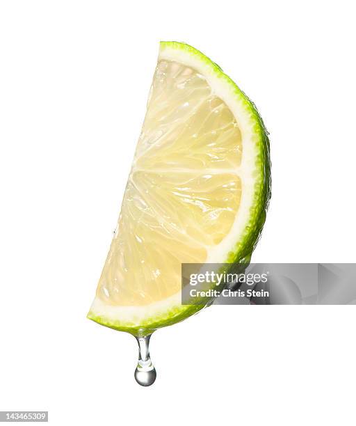 dripping wet lime wedge - limes stock pictures, royalty-free photos & images