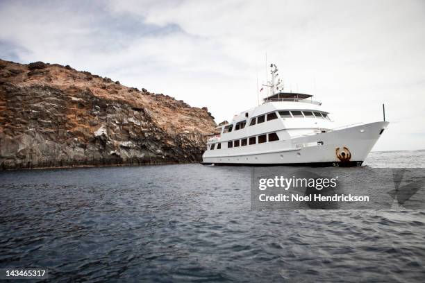 a live aboard dive boat anchored by an island - ソコロ島 ストックフォトと画像