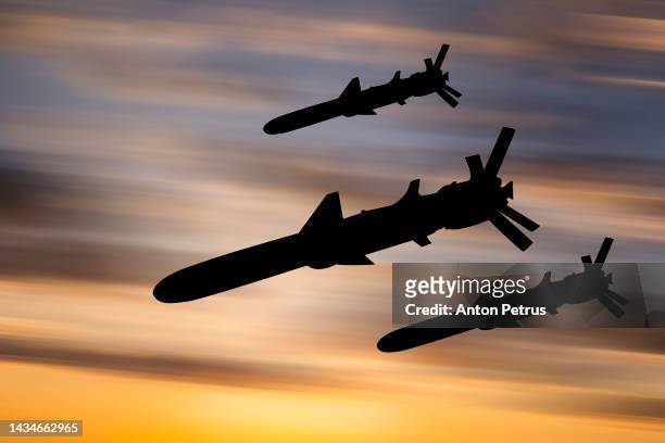 cruise missiles against the sunset sky - angriff mit bombe stock-fotos und bilder