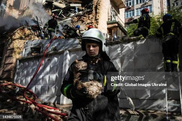 Rescuer carries a cat, which was taken out from under the rubble of residential building destroyed by kamikaze drone on October 17, 2022 in Kyiv,...