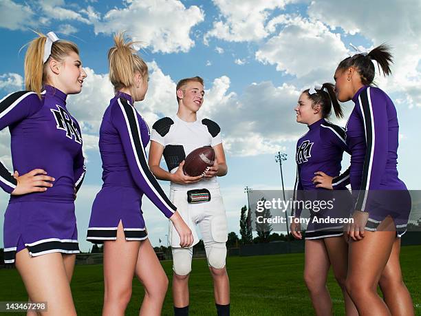 quarterback and cheerleaders talking on field - teen cheerleader - fotografias e filmes do acervo