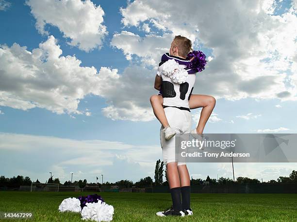 cheerleader and footballer hugging - candid cheerleaders fotografías e imágenes de stock