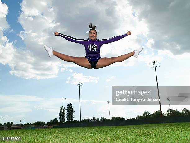 cheerleader doing toe touch jump - black cheerleaders stock pictures, royalty-free photos & images