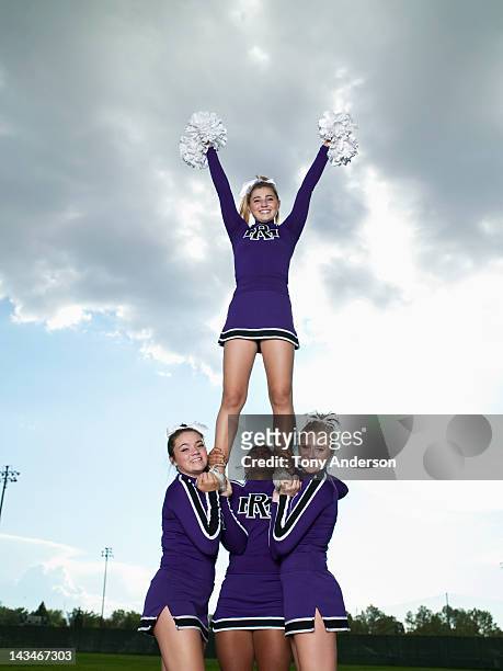 cheerleaders in pyramid formation - cheerleader photos stock pictures, royalty-free photos & images