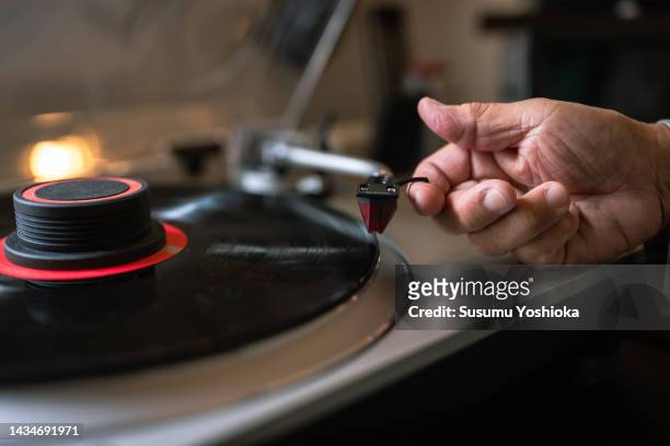 a senior man enjoying analog records in his study. - record player stock pictures, royalty-free photos & images