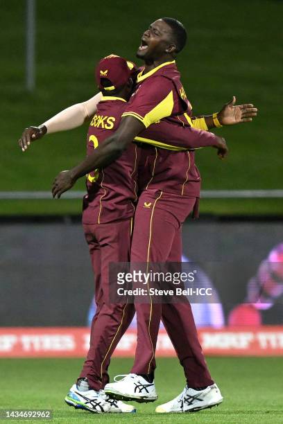 Jason Holder of the West Indies celebrates with team mates after taking the wicket of Tendai Chatara of Zimbabwe for 3 runs during the ICC Men's T20...