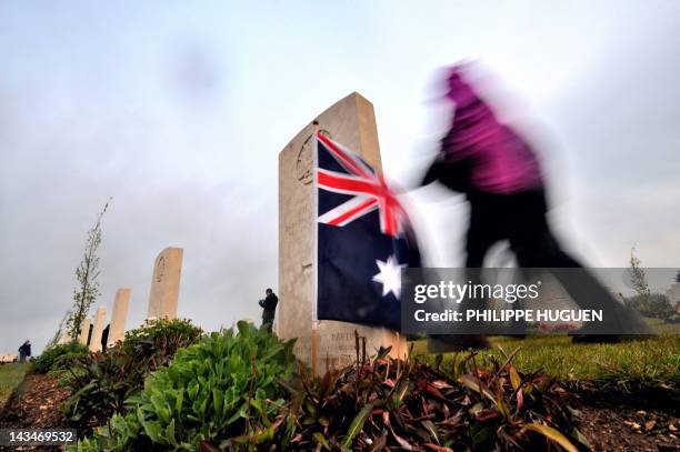 Person walks past a grave and an Australian flag at the Australian War Memorial in the northern French city of Villers-Bretonneux, on April 25, 2012...