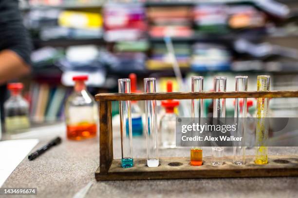 test tubes in a rack filled with multi-coloured liquid - cambridge institute laboratory stock pictures, royalty-free photos & images