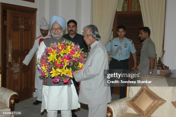 President A P J Abdul Kalam accepts a bouquet of flowers from Prime Minister Manmohan Singh on the fesival of Eid, marking the end of Ramadan, the...