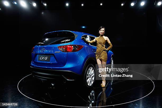 Model stands beside a Mazda CX-5 car during the 2012 Beijing International Automotive Exhibition at the Beijng International Exhibition Center on...