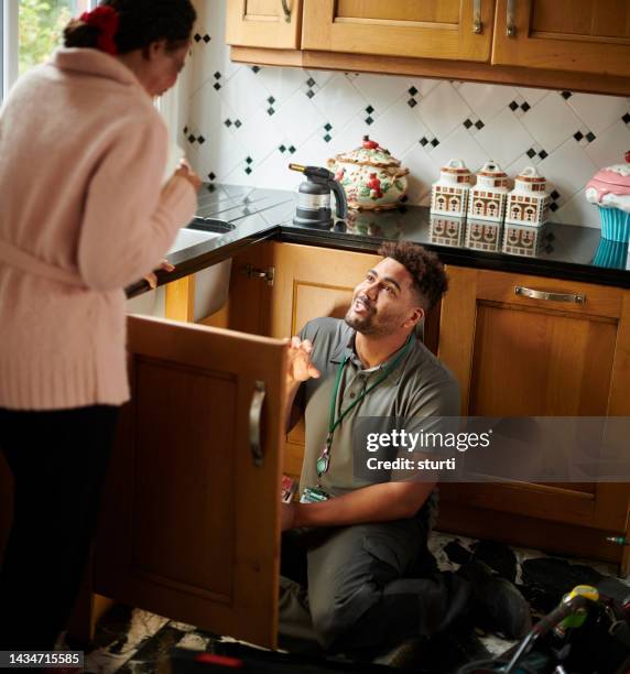 plumber fixing customer's sink - plumber stock pictures, royalty-free photos & images